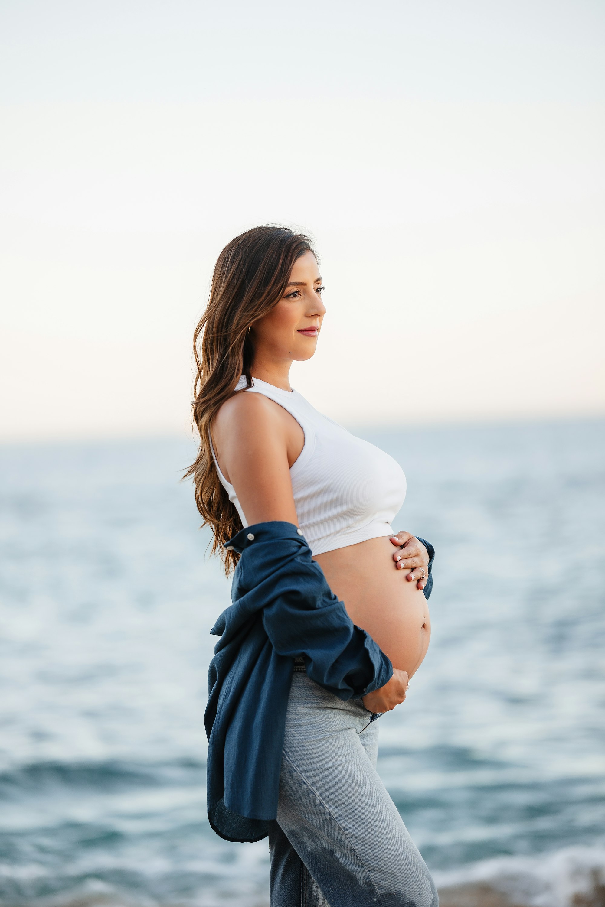 PLACEHOLDER (Unsplash) — pregnant woman standing on a beach