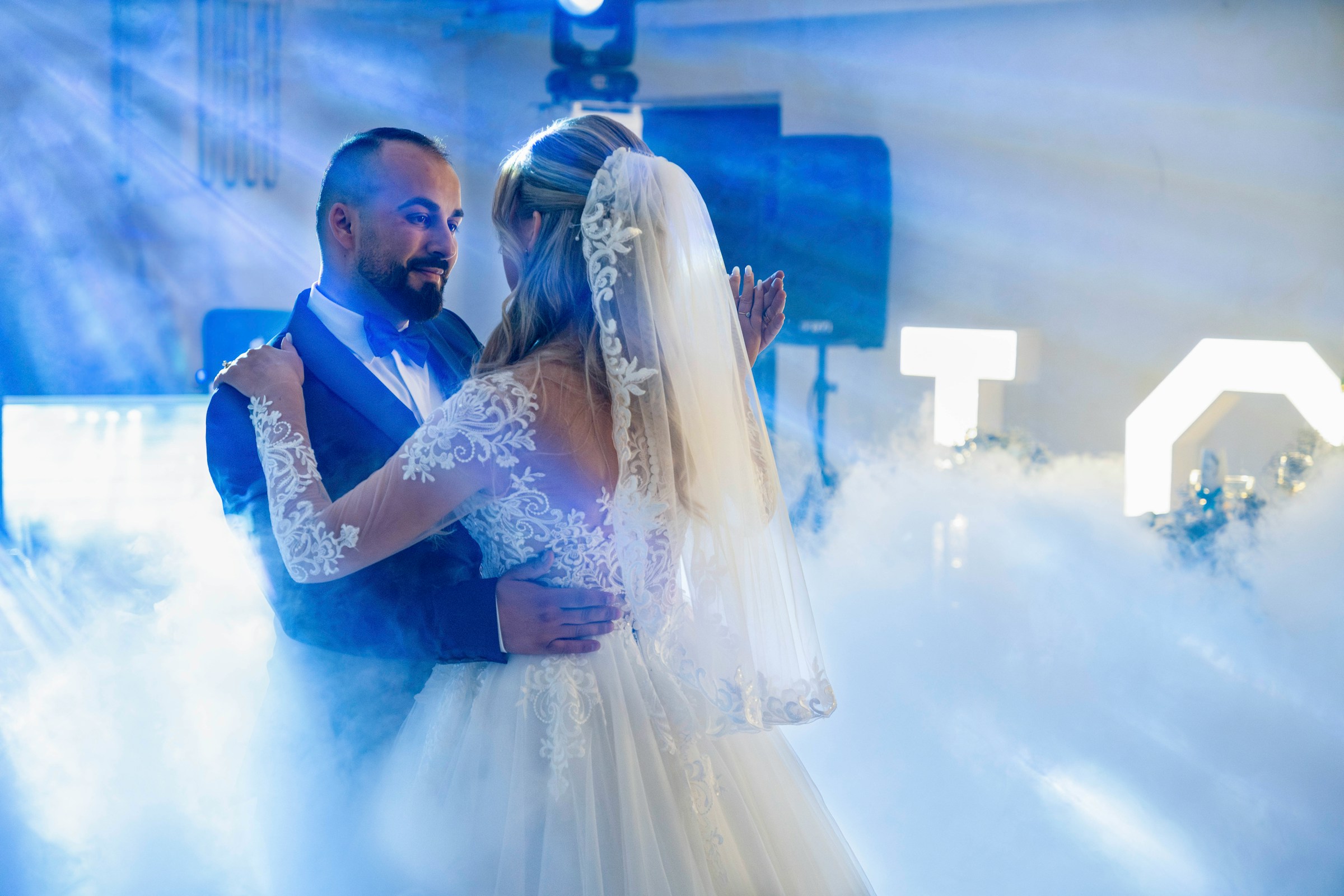 PLACEHOLDER (Unsplash) — bride and groom dancing in a cloud of smoke